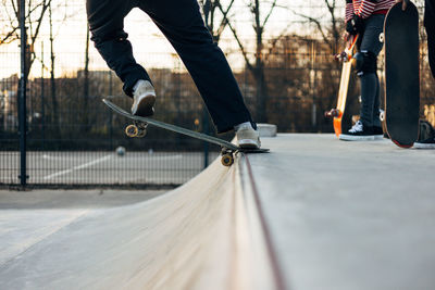 Low section of man skateboarding on road