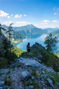 Rear view of woman on rock against sky