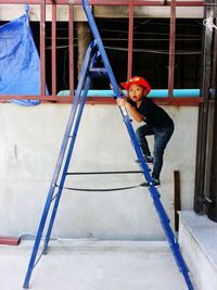 Portrait of young woman standing against built structure