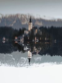 Upside down image of building by lake during winter