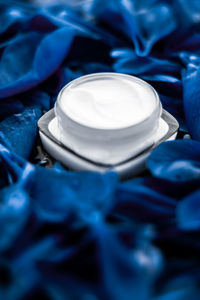 High angle view of moisturizer in container on blue textile