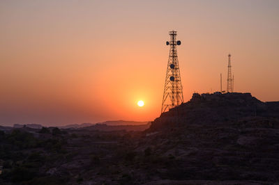 Communications tower against sky during sunset