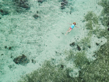 Drone view of woman swimming in sea