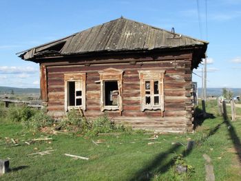 Abandoned house on field against sky