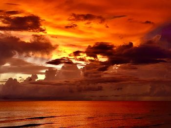 Scenic view of sea against dramatic sky during sunset