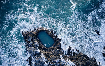 Waves crashing over rocks in sea