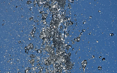 Close-up of water splashing against blue background