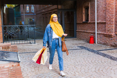 Woman with umbrella walking on street