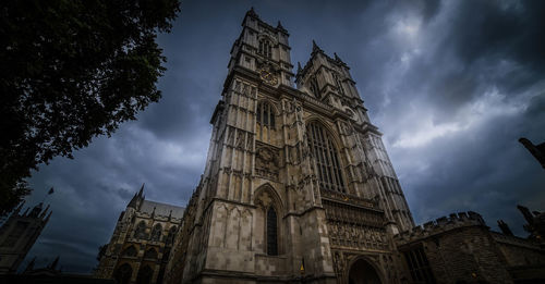 Low angle view of clock tower against cloudy sky