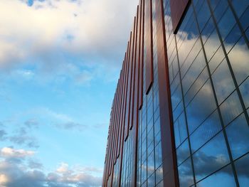 Low angle view of modern building against cloudy sky