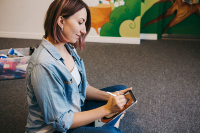 Side view of young woman reading book