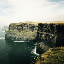 Rock formations by sea against sky