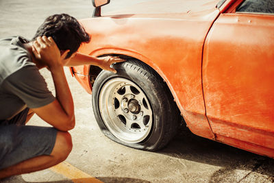 Midsection of woman holding umbrella on car