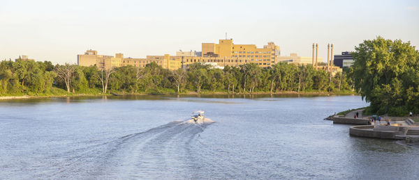 Scenic view of river by buildings against sky