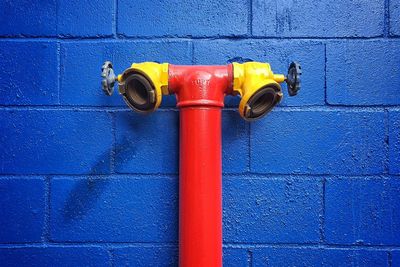 Close-up of fire hydrant against blue wall