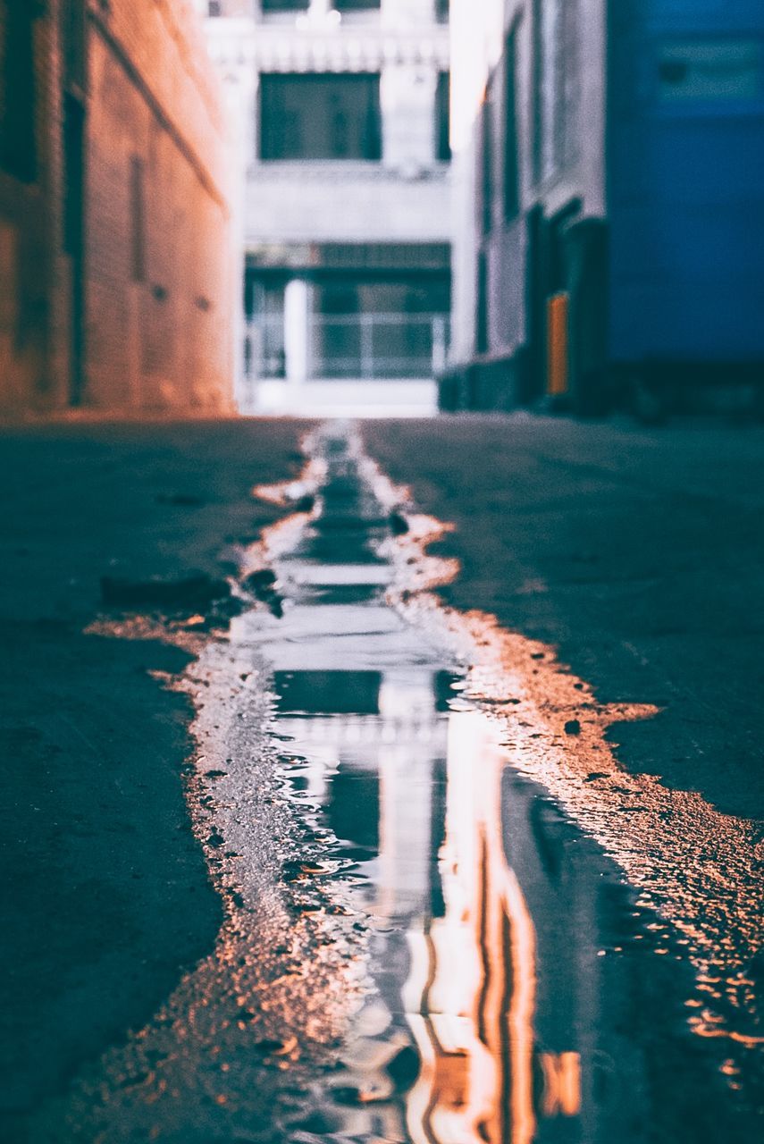 REFLECTION OF BUILDINGS IN PUDDLE