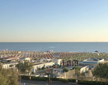 High angle view of townscape by sea against clear sky