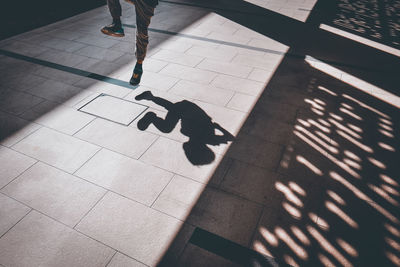 Shadow of man jumping on footpath