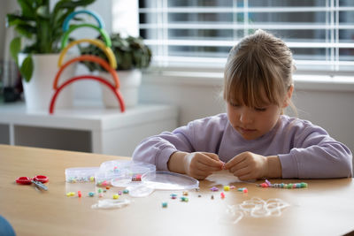 Close-up of cute girl playing with toy blocks at home