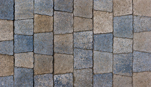 Colored trapezoid concrete tiles pavement in high angle view - full frame background and texture