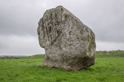 Rock on field against sky