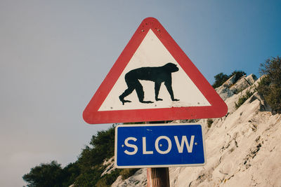 Road sign against clear blue sky