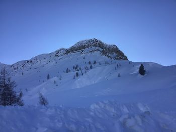 Scenic view of snowcapped mountains against clear blue sky