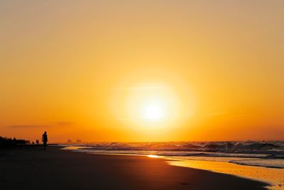 Silhouette of man on beach at sunset