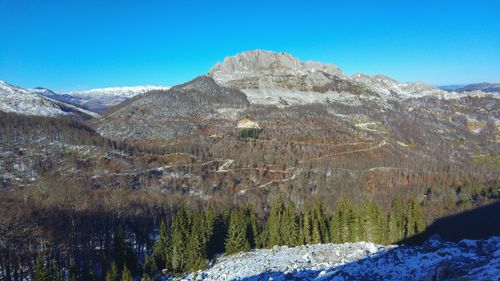 Scenic view of snowcapped mountains against blue sky