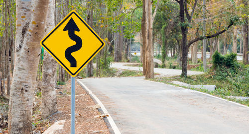 Road sign against trees