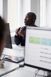 Mature businessman using headset and while sitting in office