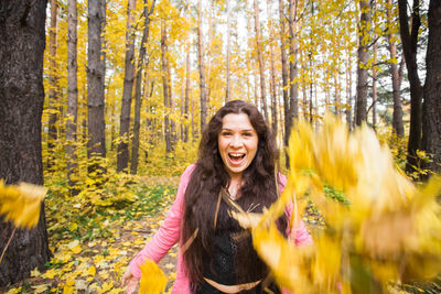 Portrait of smiling young woman in forest