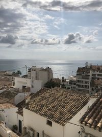 High angle view of townscape by sea against sky