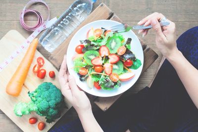 High angle view of woman holding food on table