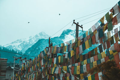 Low angle view of flags hanging against sky