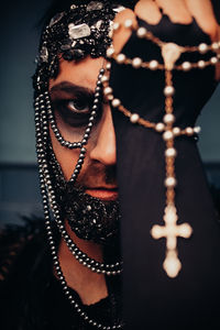 Close-up portrait of serious man in costume holding rosary