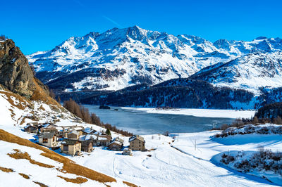 View of the village of grevasalvas, and lake sils, in engadine, switzerland, in winter.