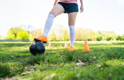 Low section of woman with ball on field