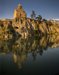 Low angle view of monastery by lake