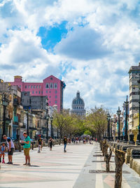 People walking on street against sky