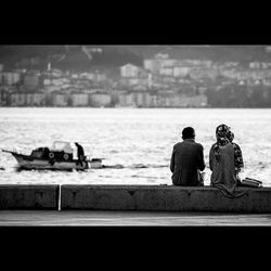 People relaxing in front of sea