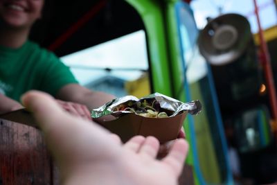 Cropped image of people with food in container