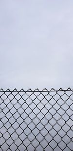 Close-up of chainlink fence against sky