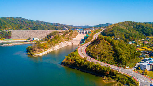 Scenic view of river by mountains against clear sky