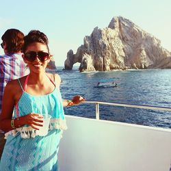 Portrait of beautiful woman standing by sea against clear sky