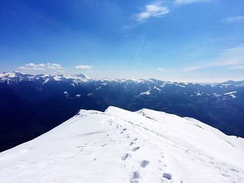 Scenic view of snowcapped mountains against cloudy sky