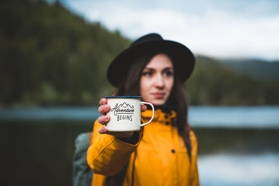 Portrait of woman standing against lake