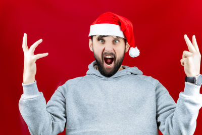 Portrait of man wearing hat against red background