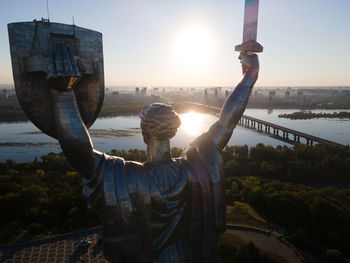 Statue in city at sunset