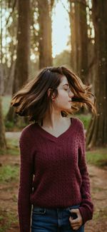 Beautiful woman wearing sunglasses standing against trees